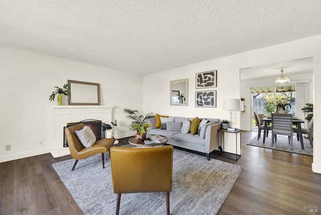 living room featuring a textured ceiling, dark wood-style flooring, and a fireplace