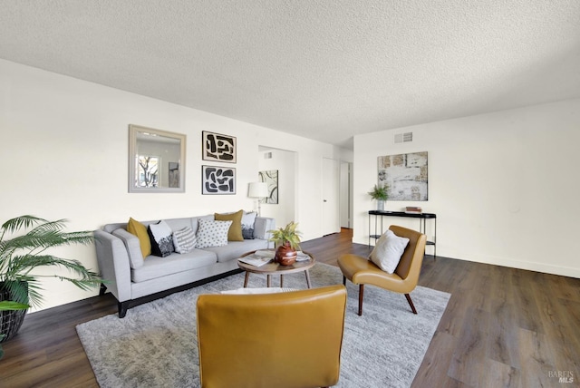 living room with a textured ceiling, wood finished floors, and visible vents