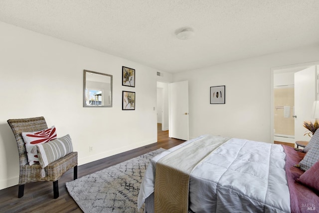 bedroom with a textured ceiling, ensuite bathroom, visible vents, baseboards, and dark wood finished floors