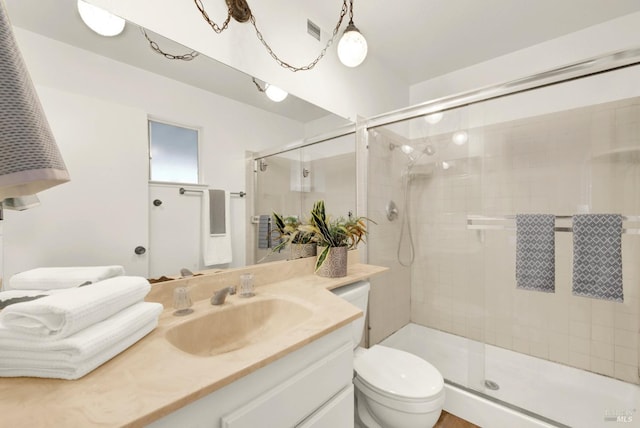 bathroom featuring toilet, a stall shower, visible vents, and vanity