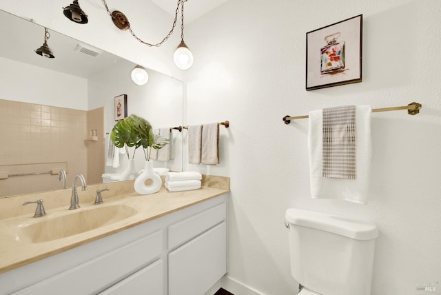 bathroom with toilet, visible vents, and vanity