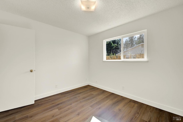 unfurnished room featuring a textured ceiling, dark wood-style flooring, and baseboards