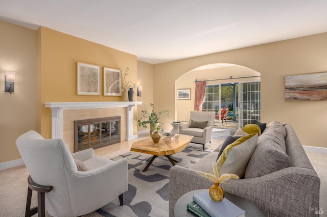 carpeted living room with a fireplace and baseboards