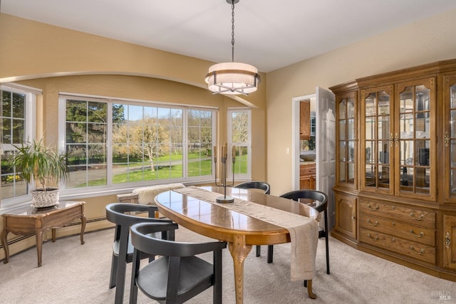 dining area with a baseboard heating unit and light colored carpet