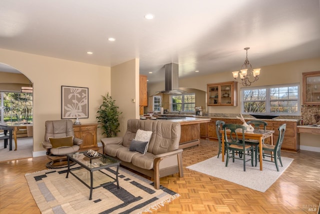 interior space featuring arched walkways, recessed lighting, a baseboard radiator, and a healthy amount of sunlight