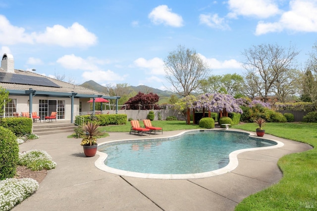 view of swimming pool featuring a fenced in pool, a lawn, fence, a patio area, and a mountain view