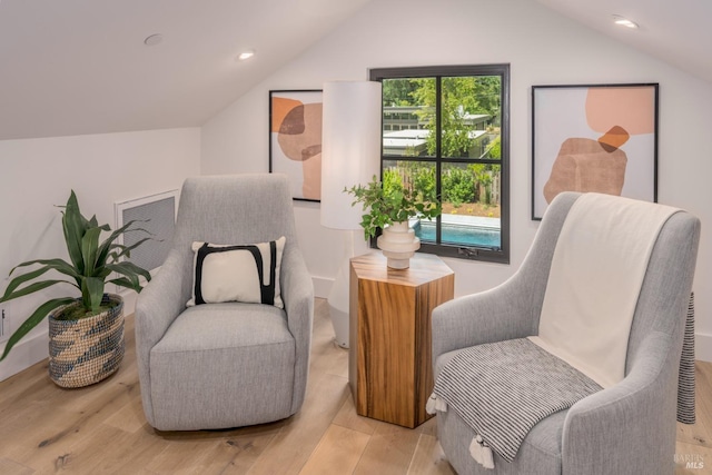 living area featuring lofted ceiling, light wood-type flooring, visible vents, and recessed lighting