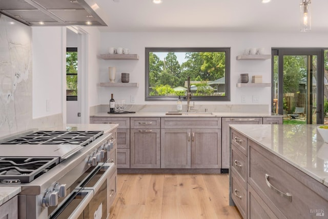 kitchen with plenty of natural light, wall chimney exhaust hood, double oven range, and open shelves