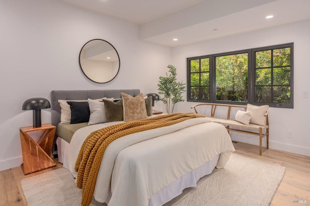 bedroom featuring baseboards, wood finished floors, and recessed lighting