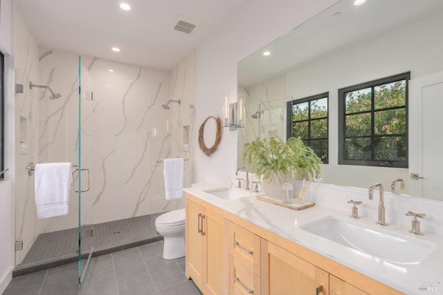 bathroom with toilet, a marble finish shower, visible vents, and a sink