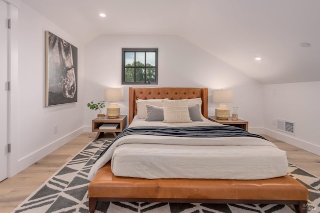 bedroom featuring lofted ceiling, light wood-style floors, baseboards, and visible vents