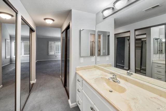 bathroom featuring visible vents, vanity, and baseboards