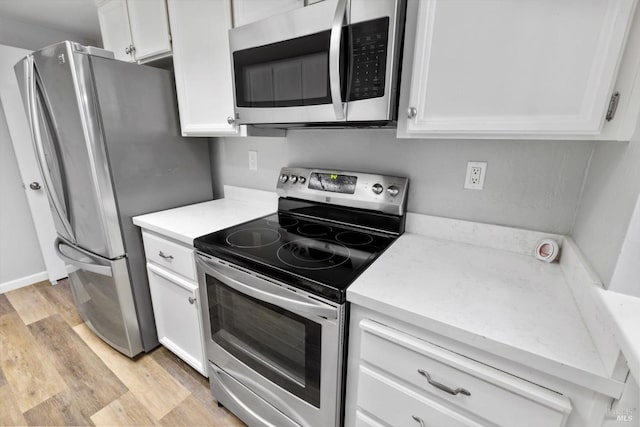 kitchen featuring stainless steel appliances, white cabinetry, and light wood-type flooring