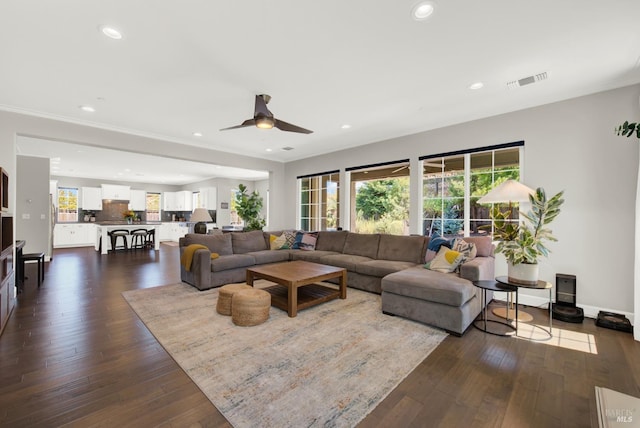 living room with baseboards, visible vents, dark wood-style flooring, and recessed lighting