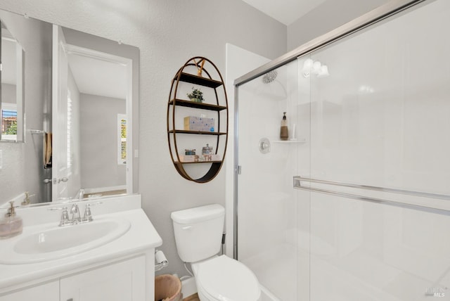 bathroom featuring a stall shower, vanity, and toilet