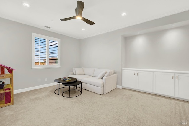 living area featuring light carpet, a ceiling fan, visible vents, and baseboards