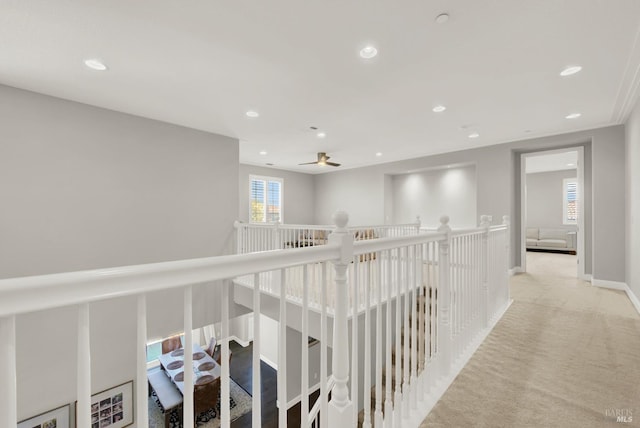 hallway featuring carpet floors, recessed lighting, baseboards, and an upstairs landing