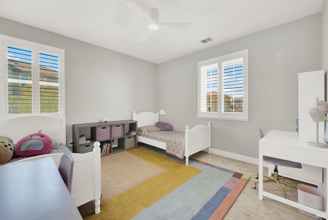 bedroom featuring a ceiling fan, visible vents, light carpet, and baseboards