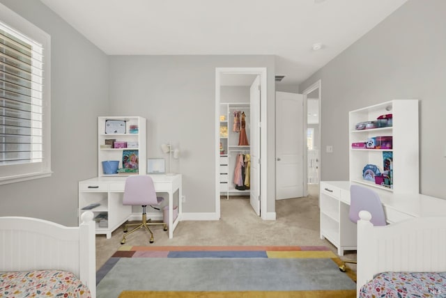 carpeted bedroom with a spacious closet, multiple windows, a closet, and baseboards