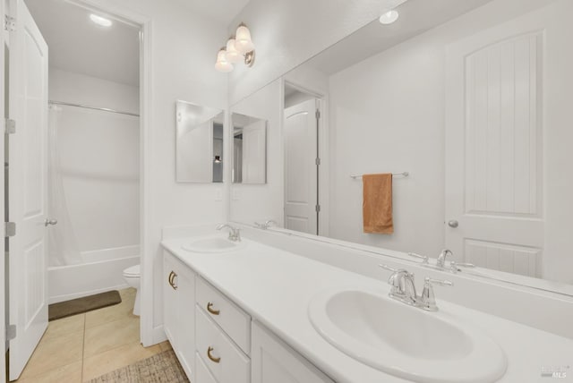 bathroom featuring tile patterned flooring, a sink, toilet, and double vanity