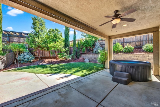 view of patio featuring a hot tub, a fenced backyard, ceiling fan, and cooling unit