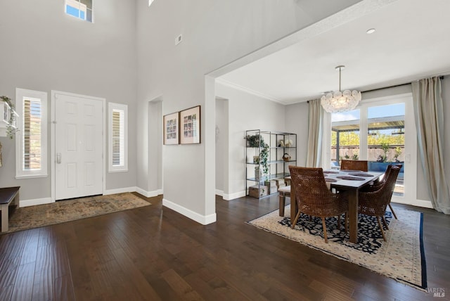 foyer entrance featuring baseboards, dark wood finished floors, a wealth of natural light, and an inviting chandelier