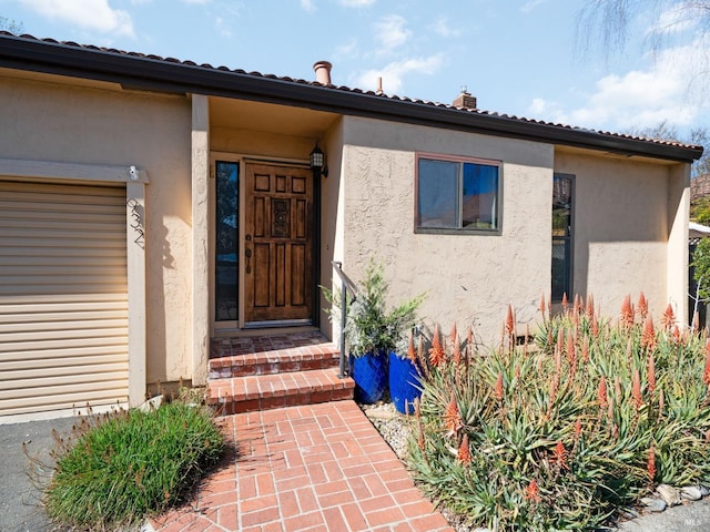 doorway to property featuring stucco siding