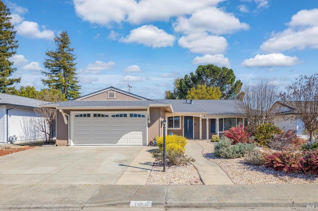 ranch-style home featuring an attached garage, driveway, and stucco siding