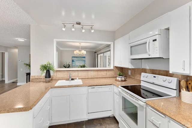 kitchen with white appliances, white cabinets, a sink, a textured ceiling, and backsplash