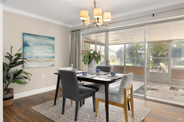 dining space with an inviting chandelier, baseboards, crown molding, and wood finished floors