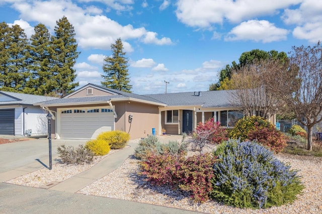 ranch-style house with driveway, an attached garage, and stucco siding