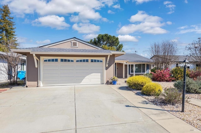 single story home featuring an attached garage, roof with shingles, concrete driveway, and stucco siding