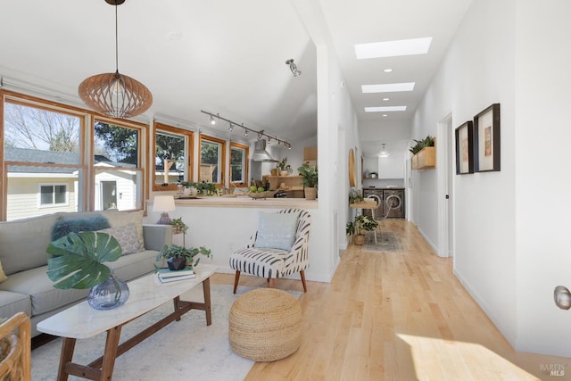 living area with a skylight, baseboards, wood finished floors, track lighting, and recessed lighting