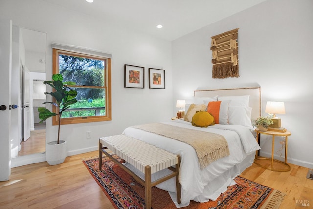 bedroom with light wood-type flooring, baseboards, and recessed lighting