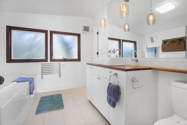 full bathroom with vaulted ceiling, toilet, a garden tub, and visible vents