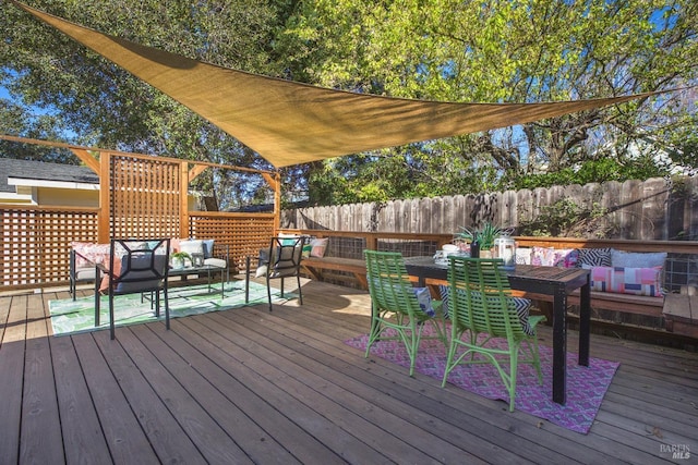 wooden terrace with outdoor dining area, outdoor lounge area, and fence