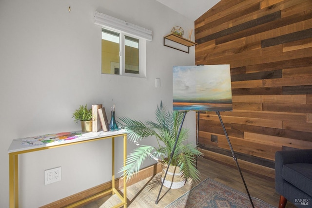 interior space featuring vaulted ceiling, wood finished floors, and wooden walls