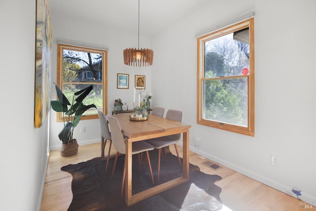 dining area featuring a wealth of natural light, wood finished floors, visible vents, and baseboards