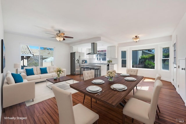 dining space featuring a ceiling fan, baseboards, and wood finished floors