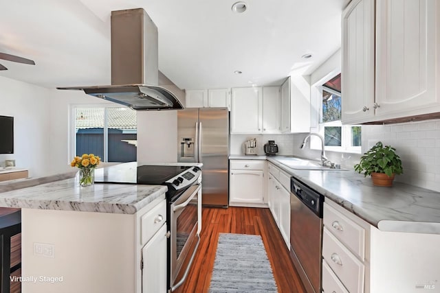 kitchen with island range hood, decorative backsplash, a kitchen island, appliances with stainless steel finishes, and a sink