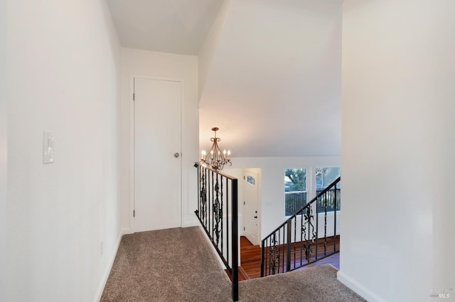 stairs with baseboards, carpet floors, and an inviting chandelier