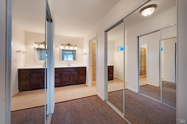 bathroom featuring carpet, vanity, and baseboards