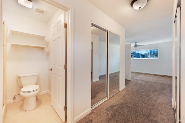 interior space featuring carpet flooring, tile patterned flooring, visible vents, and baseboards