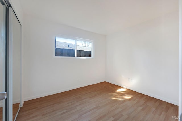 unfurnished room featuring light wood finished floors and baseboards