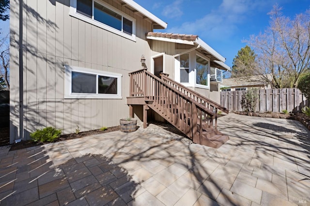 exterior space featuring a patio area, fence, and stairs