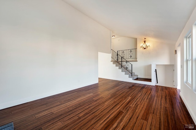 interior space with lofted ceiling, a notable chandelier, baseboards, stairs, and dark wood-style floors