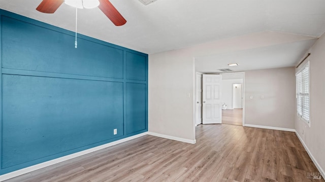 empty room with visible vents, ceiling fan, baseboards, and wood finished floors