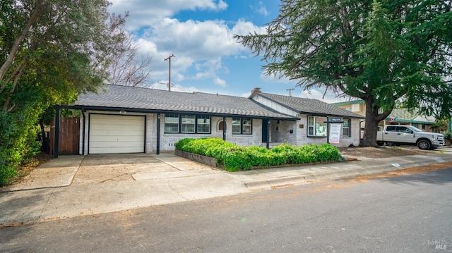 single story home featuring a garage, brick siding, and driveway