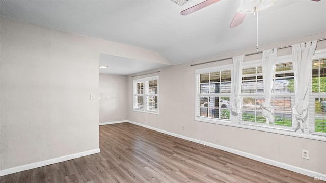 spare room with a ceiling fan, baseboards, and wood finished floors