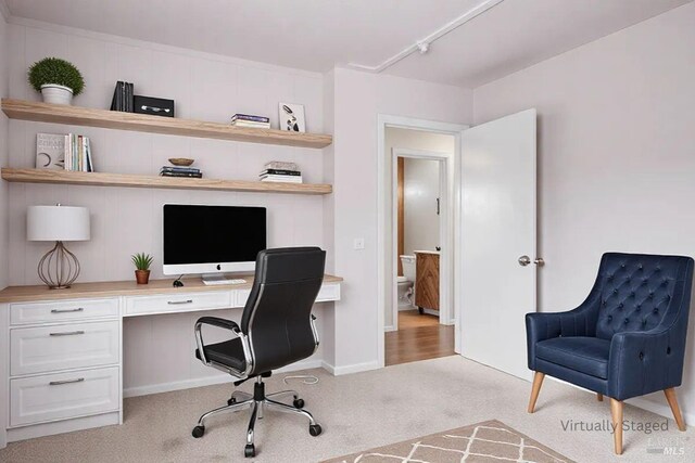 office space with light colored carpet and built in study area